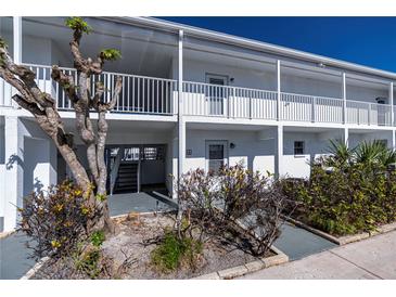 Inviting condo exterior featuring well-kept landscaping and a clean, bright facade with white railings at 902 Gibbs Rd # 181, Venice, FL 34285