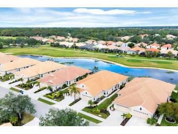Beautiful aerial view of homes with tile roofs and lush landscaping near a golf course and scenic pond at 1697 San Silvestro Dr, Venice, FL 34285