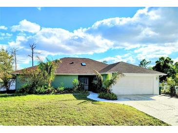 Charming single-story home with a lush front yard and a spacious two-car garage at 23495 Altman Ave, Punta Gorda, FL 33980