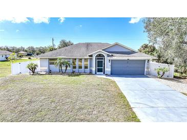 Charming single-story home with a well-maintained lawn and a two-car garage and welcoming front entrance at 2783 Biscayne Dr, North Port, FL 34287