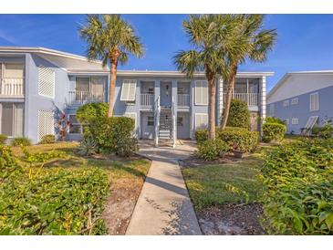 A beautiful two-story condo with a charming walkway and mature tropical landscaping at 454 Cerromar Rd # 174, Venice, FL 34293