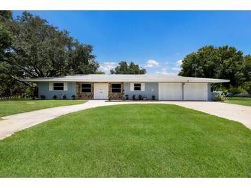 Charming single-story home featuring a stone accent, a well-manicured lawn, and an extra wide driveway at 651 Percheron Cir, Nokomis, FL 34275