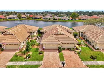 Beautiful home with well-manicured lawn, landscaping, and a brick driveway located on a waterfront property at 1056 Topelis Dr, Englewood, FL 34223