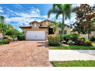 Charming single-story home with a brick driveway, lush landscaping, and a two-car garage at 1088 Bluffwood Dr, Nokomis, FL 34275