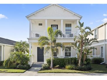 Charming two-story home with a welcoming front porch and lush tropical landscaping at 12679 Sagewood Dr, Venice, FL 34293