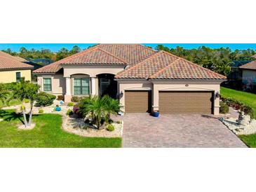 Beautiful single-story home with a brick driveway, two-car garage, and well-manicured landscaping at 13652 Classico Ct, Venice, FL 34293