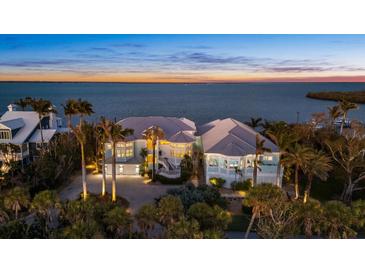 Stunning waterfront home featuring lush landscaping and breathtaking sunset views at 14 Grouper Hole Dr, Boca Grande, FL 33921