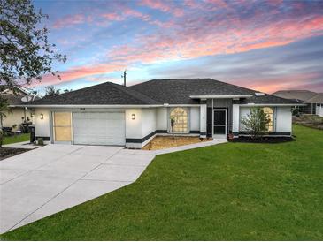 Charming single-story home with well-manicured lawn and two-car garage at 2114 S Biscayne Dr, North Port, FL 34287
