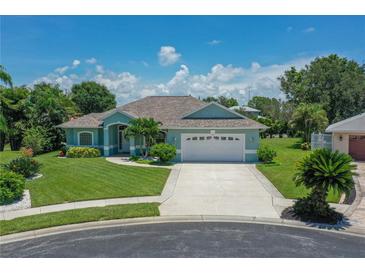 Charming home boasts lush landscaping, a well-manicured lawn, and a welcoming two-car garage at 213 Bayside Ct, Nokomis, FL 34275
