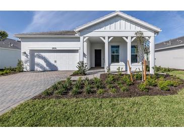 Charming single-story home featuring a well-manicured lawn, paver driveway, and a welcoming porch at 29176 Coral Harbour Dr, Englewood, FL 34223