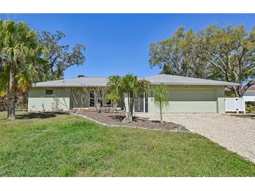 Charming single-story home with a well-maintained lawn and mature trees creating curb appeal at 1201 Ewing St, Nokomis, FL 34275