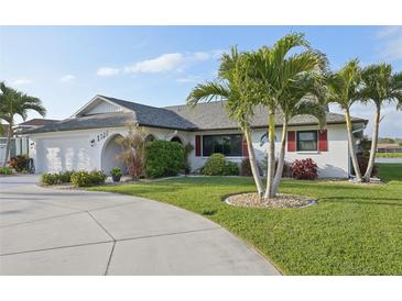 Charming single-story home featuring tropical landscaping, palm trees, and a well-manicured lawn at 1300 Lucaya Ave, Venice, FL 34285