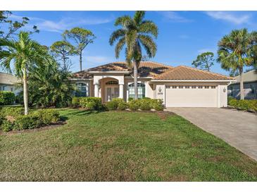 Charming single-story home with a lush green lawn, mature trees, and well-maintained landscaping at 2175 Calusa Lakes Blvd, Nokomis, FL 34275