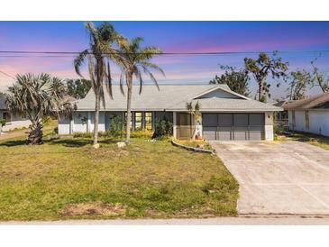 Charming single-story home featuring a well-maintained lawn and mature palm trees in a serene neighborhood at 221 Mark Twain Ln, Rotonda West, FL 33947