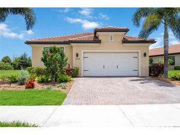 Charming single-story home featuring a tile roof, brick driveway, and well-maintained landscaping at 24036 Spartina Dr, Venice, FL 34293