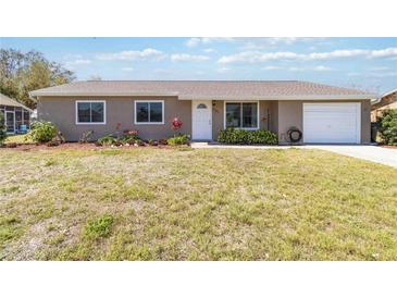 Charming one-story home with a well-manicured lawn, lovely landscaping, and an attached one car garage at 2983 Greendale Rd, North Port, FL 34287