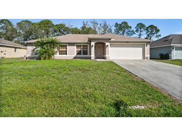 Charming single-story home featuring a well-maintained lawn and an attached two-car garage at 5458 Jessamine Ave, North Port, FL 34291