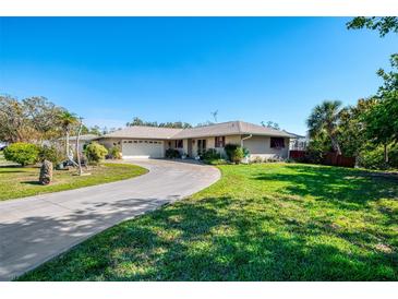 Charming home featuring an expansive green lawn and long paved driveway at 6146 Rockefeller Ave, Sarasota, FL 34231