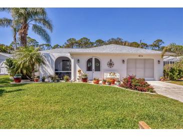 Charming single-story home with a well-manicured lawn, mature landscaping, and a welcoming front entrance at 6216 Pecan Rd, Venice, FL 34293