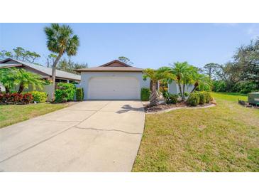 Charming single-story home with well-manicured landscaping and a spacious driveway at 647 Linden Dr, Englewood, FL 34223