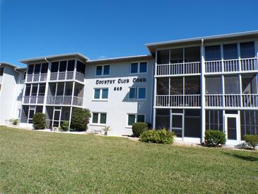 Exterior view of a two-story condo complex with screened balconies and well-maintained landscaping at 649 S Tamiami S Trl # 304, Venice, FL 34285