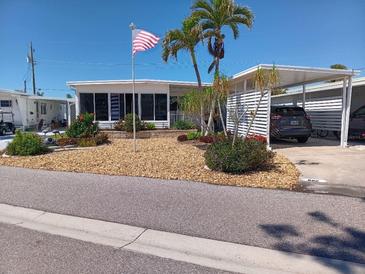 Charming single-story home featuring a carport, well-manicured landscaping, and a welcoming front facade at 822 Bogie St, Venice, FL 34285