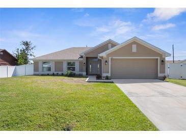 Charming single-story home with a well-manicured lawn, inviting front entrance, and attached two-car garage at 1087 Piedmont Rd, Venice, FL 34293