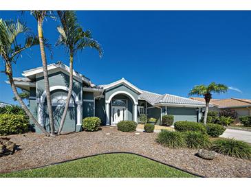 Charming single-story home featuring lush landscaping, palm trees, and a welcoming front entrance at 1125 Deardon Dr, Venice, FL 34292