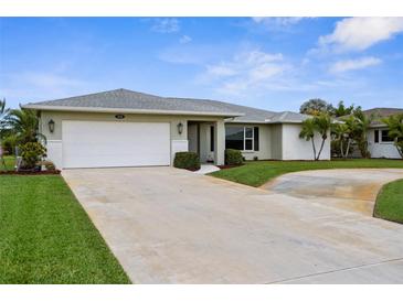Well maintained house with a two-car garage, mature palms and landscaping and large driveway at 1726 Claw Ct, Venice, FL 34293