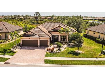 Beautiful single-story home featuring a tile roof, well-manicured lawn, and a two-car garage at 20806 Valprato Ct, Venice, FL 34293