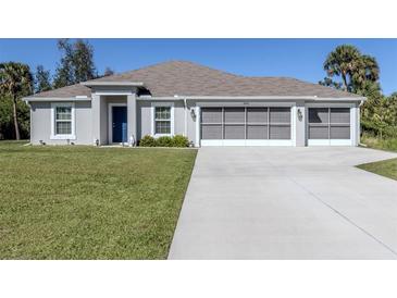 Charming single-story home with a well-maintained lawn, and a three car garage at 2450 Sahara Ln, North Port, FL 34286