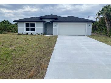 Charming single-story home with a well-manicured lawn and a two-car garage at 2643 Orchard Cir, North Port, FL 34288