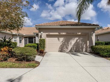 Charming home featuring a well-manicured lawn, beige exterior, and a convenient two-car garage at 4123 Cascade Falls Dr, Sarasota, FL 34243