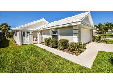 Charming single-story home with well-manicured lawn, white tile roof, and inviting front entrance at 782 Harrington Lake N Dr # 99, Venice, FL 34293