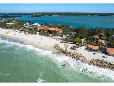 Stunning aerial view of a beachfront estate with turquoise waters and a sandy beach at 1049 N Casey Key Rd, Osprey, FL 34229