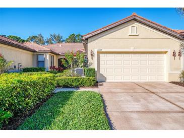 Charming single-story home with well-maintained landscaping and a two-car garage at 11157 Batello Dr, Venice, FL 34292