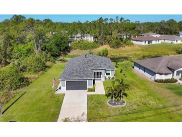 Aerial view of a house with a well-manicured lawn and landscaping at 1207 Henning St, North Port, FL 34288