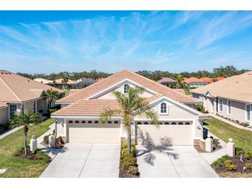 Inviting home featuring a well-manicured lawn, a tile roof, and a spacious driveway at 1683 San Silvestro Dr, Venice, FL 34285