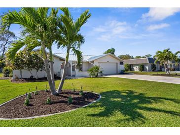 Charming single-story home with lush lawn, mature palms, and light exterior paint at 201 Cavallini Dr, Nokomis, FL 34275