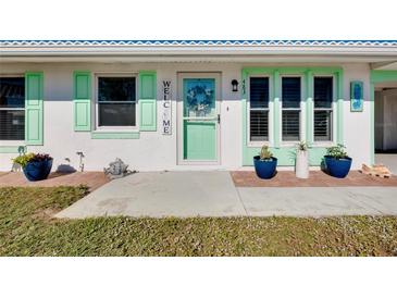 Charming home featuring a welcoming front entrance with a vibrant turquoise door and seaside decor at 483 Circlewood Dr # O14, Venice, FL 34293