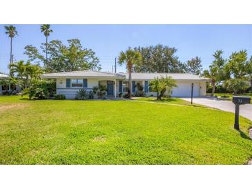 Charming single-story home with a well-manicured lawn and lush landscaping at 51 Oakwood N Dr # 51, Englewood, FL 34223