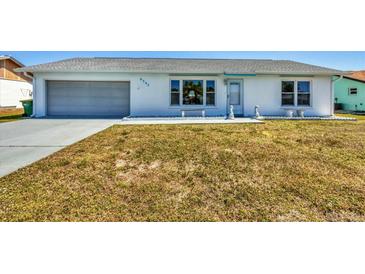 Charming single-story home featuring a well-maintained front yard and an attached garage at 6392 Coliseum Blvd, Port Charlotte, FL 33981