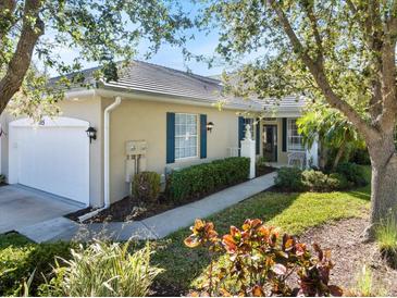 Charming single-story home with lush landscaping, blue shutters and a tile roof at 915 Tartan Dr # 29, Venice, FL 34293