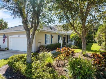 Charming home featuring a well-manicured front yard with vibrant landscaping and a welcoming entrance at 915 Tartan Dr # 29, Venice, FL 34293