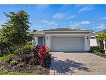 Beautiful single-story home featuring a manicured lawn and a welcoming two-car garage at 9800 Bright Water Dr, Englewood, FL 34223