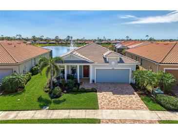 Charming single-Gathering home with a brick driveway, lush landscaping, and water view at 11803 Sistine Ln, Venice, FL 34293