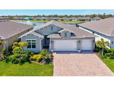 Beautiful single Gathering home with a 3 car garage, well manicured lawn, and gorgeous lake view at 1606 Cedar Valley Dr, Port Charlotte, FL 33953