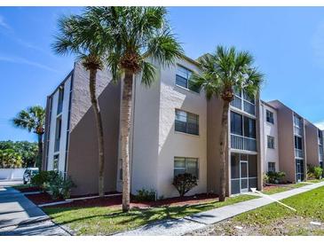 Condo exterior showcases a well-maintained building with lush landscaping and inviting screened-in balconies at 519 Albee Farm Rd # 116, Venice, FL 34285
