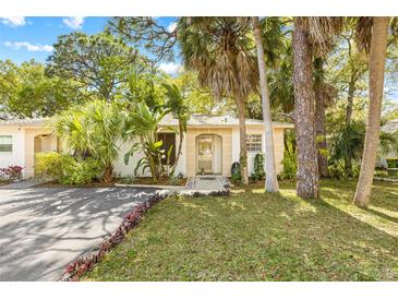 Charming single-story home with well-manicured lawn, mature tropical foliage, and inviting front entrance at 614 N Jefferson Ave # 27, Sarasota, FL 34237