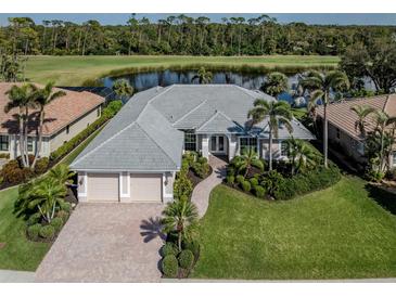 Beautiful home with lush landscaping, mature palms and golf course views at 692 Egret Walk Ln, Venice, FL 34292